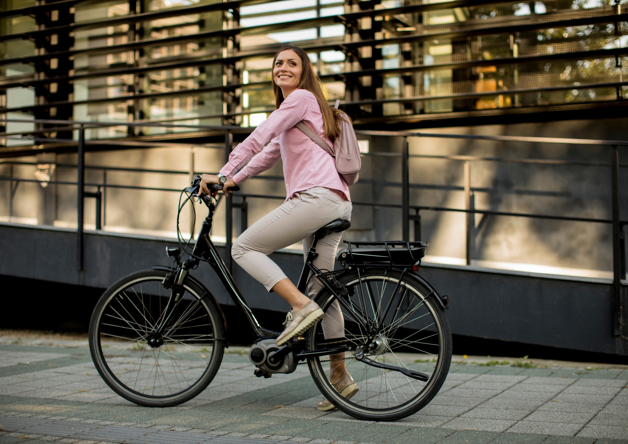 Urban rider on an e-bike outside a modern city building